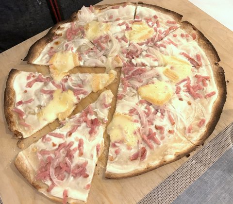la part de tarte flambée est mangée avec les doigt